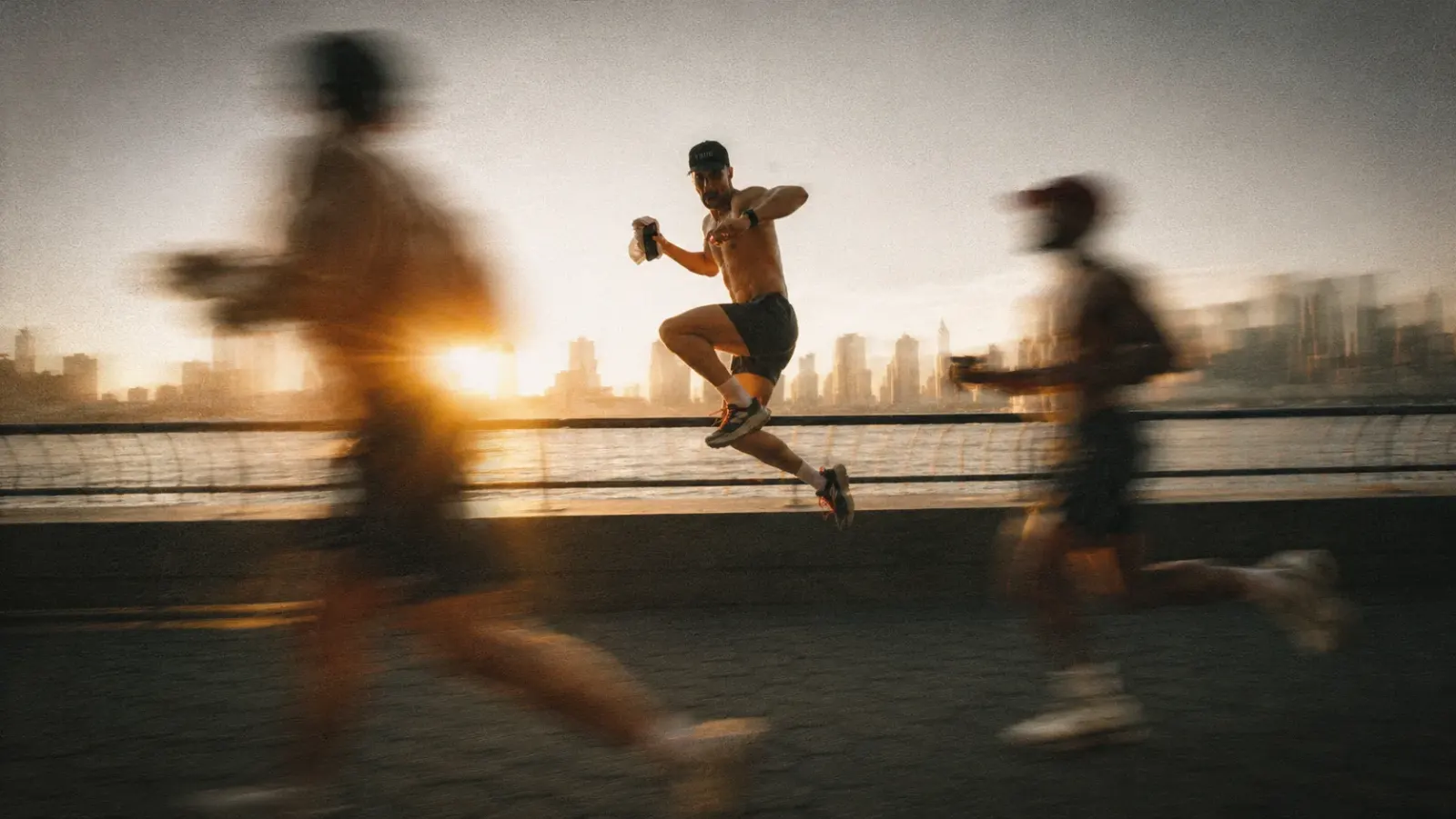 Personas corriendo junto al agua al atardecer